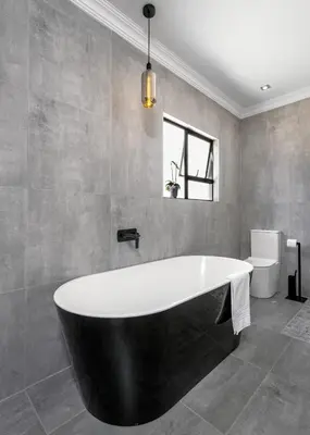 a bath tub in a bathroom with a window at Woman Era Guesthouse in Midrand