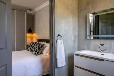 a bathroom with a bed and a sink at Woman Era Guesthouse in Midrand