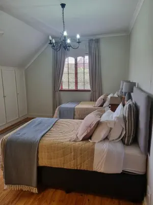 a bedroom with two beds and a chandelier at The Jones in Kaapsehoop
