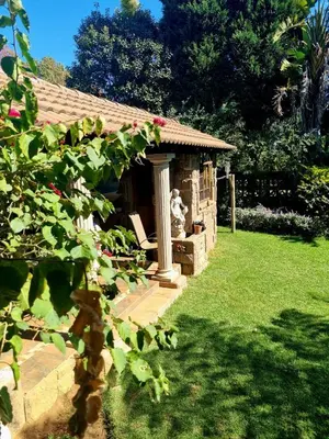 a gazebo with a tiled roof in a garden at The Jones in Kaapsehoop