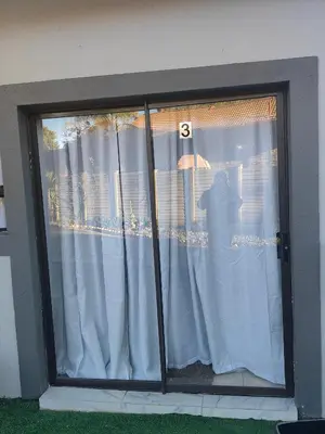 a window with white curtains in a house at Choosers Express Boutique Hotel Room 3 in Centurion