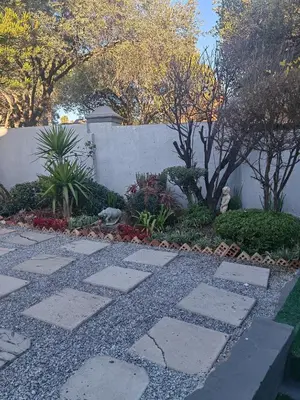 a garden with a stone walkway in front of a wall at Choosers Express Boutique Hotel Room 3 in Centurion