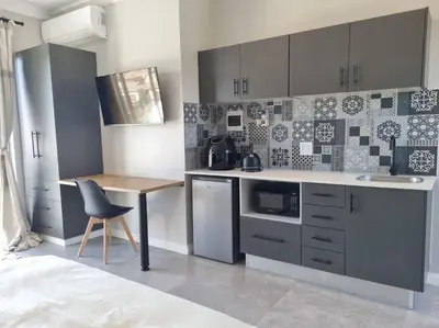 a small kitchen with a table and a chair at Silver Views Guest Suite - No loadshedding! in Pretoria
