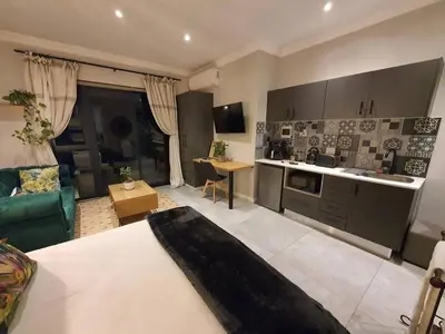 a kitchen and living room with a couch and a table at Silver Views Guest Suite - No loadshedding! in Pretoria