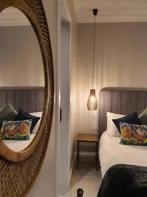 a bedroom with a mirror and a bed with pillows at Silver Views Guest Suite - No loadshedding! in Pretoria