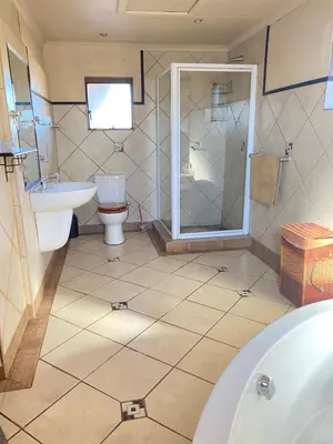 a bathroom with a tub and a toilet and a sink at Texas Phalaborwa guesthouse in Phalaborwa