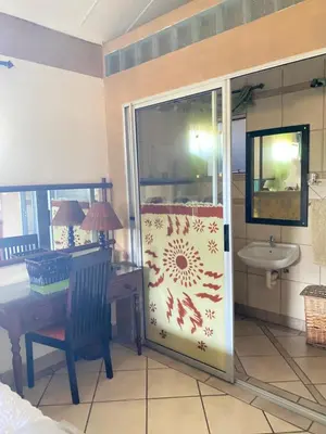 a bathroom with a shower with a sink and a table at Texas Phalaborwa guesthouse in Phalaborwa