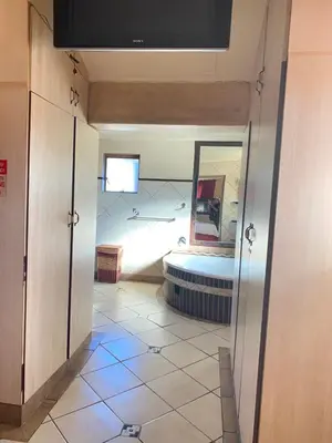 a hallway with a bathroom with a mirror and a tub at Texas Phalaborwa guesthouse in Phalaborwa