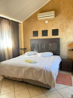 a bedroom with a large bed with a white comforter at Texas Phalaborwa guesthouse in Phalaborwa
