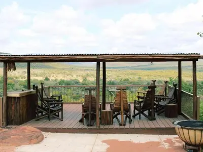 a deck with chairs and tables and a view at Zomoya Game Farm in Vaalwater
