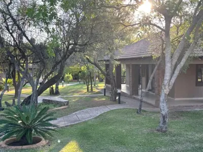 a park with trees and a building with a pathway at Zomoya Game Farm in Vaalwater