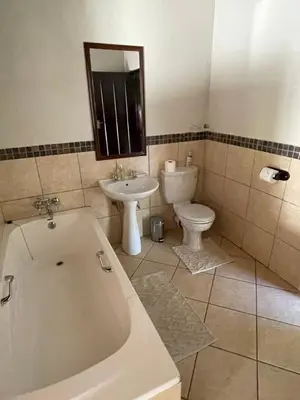 a bathroom with a tub and a toilet and a sink at Zomoya Game Farm in Vaalwater