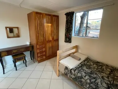 a bedroom with a bed and a desk and a window at Zomoya Game Farm in Vaalwater