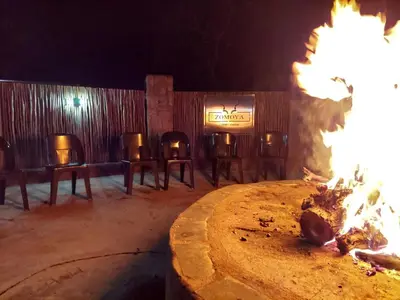 a fire pit with a group of chairs and tables at Zomoya Game Farm in Vaalwater