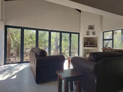 a living room with two couches and a table at House Motswiri in Marloth Park
