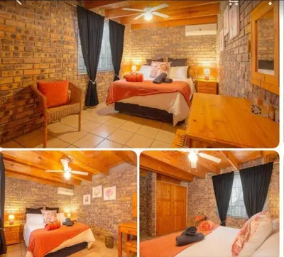 a room with two beds and a brick wall at Ton & Trees in Marloth Park