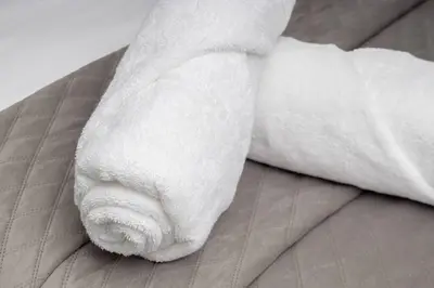 a white towel laying on top of a bed at Modern Luxury Apartment, Ellipse in Midrand