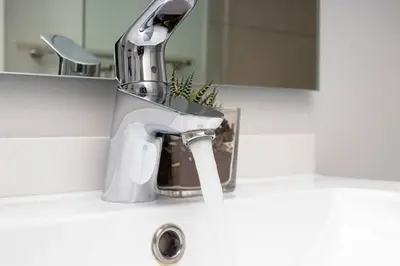 a bathroom sink with a faucet with water coming out at Modern Luxury Apartment, Ellipse in Midrand