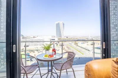 a table with a bowl of fruit and a view of the beach at Modern Luxury Apartment, Ellipse in Midrand