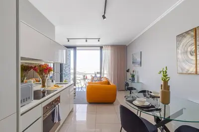 a kitchen and living room with a glass table at Modern Luxury Apartment, Ellipse in Midrand