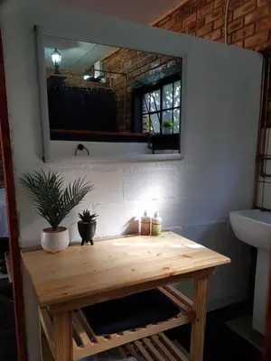 a wooden table in a bathroom with a mirror at 2K City Studios Not Self catering in Graskop