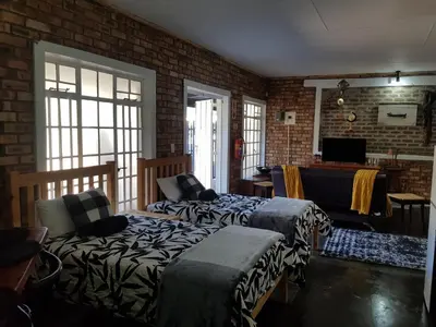 a living room with two beds and a table at 2K City Studios Not Self catering in Graskop