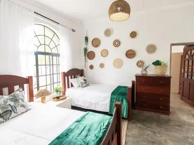 a bedroom with two beds and a dresser at BelofteBos Farmhouse Inn in Bandelierkop