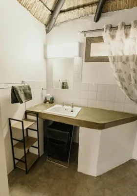 a bathroom with a sink and a counter with a mirror at BelofteBos Farmhouse Inn in Bandelierkop