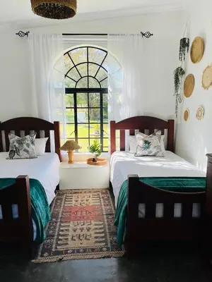 two beds in a room with a window at BelofteBos Farmhouse Inn in Bandelierkop