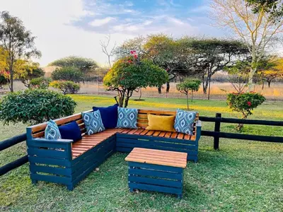 a blue bench with colorful pillows on it at BelofteBos Farmhouse Inn in Bandelierkop