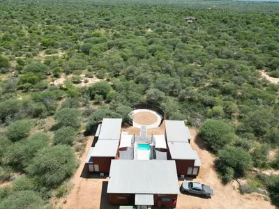 an aerial view of a house with a pool and trees at Emintha Log House in Mmukubyane