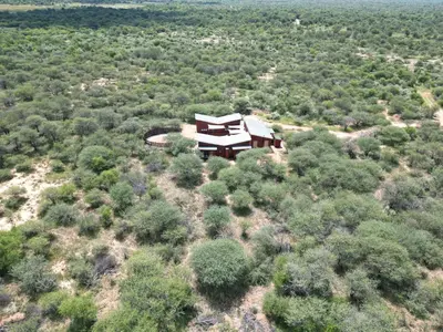 an aerial view of a house on a hill with trees at Emintha Log House in Mmukubyane