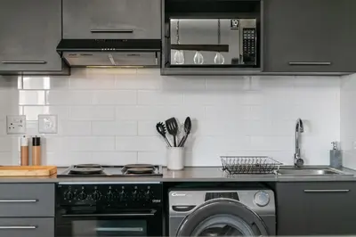a kitchen with a washing machine and a microwave at Stylish Stunner in Circa 205 in Pretoria