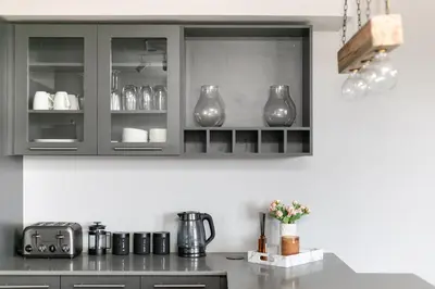 a kitchen with gray cabinets with vases at Stylish Stunner in Circa 205 in Pretoria