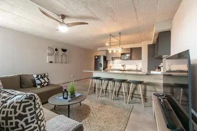 a living room with a couch and a kitchen at Stylish Stunner in Circa 205 in Pretoria