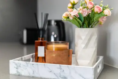 a tray with a vase of flowers and a candle at Stylish Stunner in Circa 205 in Pretoria
