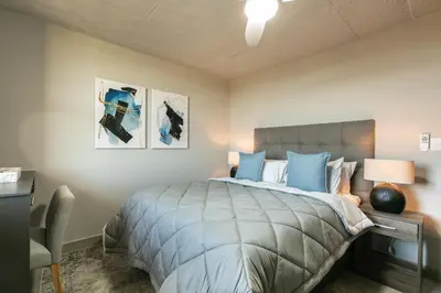 a bedroom with a bed and a desk with a lamp at Stylish Stunner in Circa 205 in Pretoria
