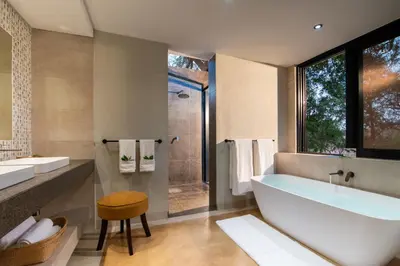 a bathroom with a tub and a sink and a shower at Idube Game Reserve in Sabi Sand Game Reserve