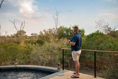 a man standing on a deck next to a hot tub at Idube Game Reserve in Sabi Sand Game Reserve