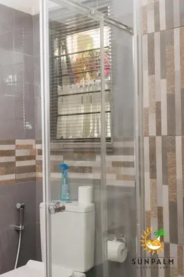 a bathroom with a toilet and a glass shower at Sunpalm Guesthouse in Nelspruit