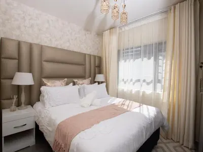 a bedroom with a large bed and a window at Elegance At Waterfall Ridge in Midrand