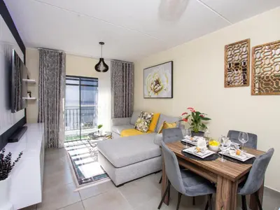 a living room with a table and a couch at Elegance At Waterfall Ridge in Midrand