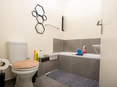 a bathroom with a toilet and a sink and a tub at Elegance At Waterfall Ridge in Midrand
