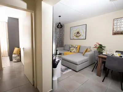 a living room with a couch and a table at Elegance At Waterfall Ridge in Midrand