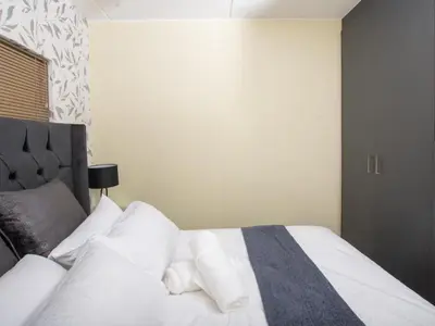 a bedroom with a white bed with white pillows at Elegance At Waterfall Ridge in Midrand