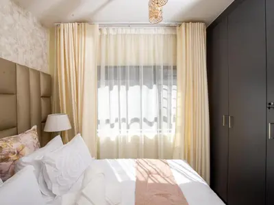 a bedroom with a bed and a large window at Elegance At Waterfall Ridge in Midrand