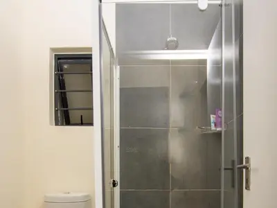 a shower with a glass door in a bathroom at Elegance At Waterfall Ridge in Midrand