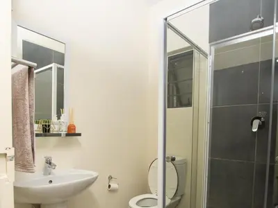 a bathroom with a toilet and a sink and a shower at Elegance At Waterfall Ridge in Midrand