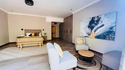 a bedroom with a bed and a living room at Ikigai4617 Villa in Marloth Park