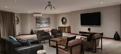 a living room with couches and a flat screen tv at Ikigai4617 Villa in Marloth Park